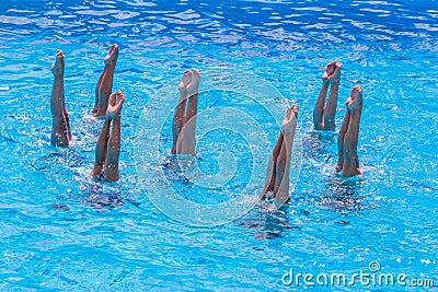 Synchronised swimming. Beautiful lean female legs in the water of a swimming pool. Concept of beauty, artistry Stock Photo