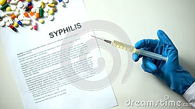 Syphilis diagnosis written on paper hand holding medication in syringe treatment Stock Photo