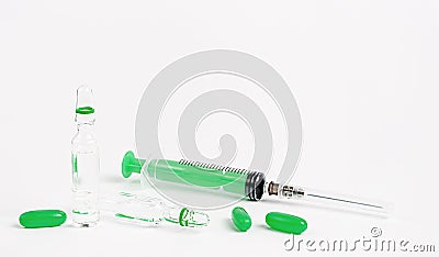 Syringe, ampules and green pills on white background. Medical treatment and vaccination concept. Stock Photo