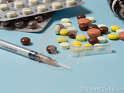 syringe and different of medicines, medicines, pills and vitamins are laid out on a blue background. Stock Photo