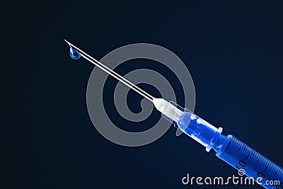 Syringe filled with drug and dripping from the needle Stock Photo