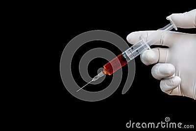 Syringe in a hand in medical gloves. Stock Photo