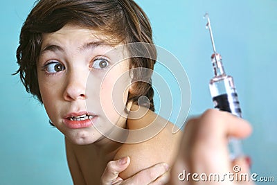 Syringe with injection vaccination. Boy is afraid. Stock Photo