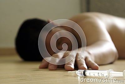 Syringe and male addict on floor Stock Photo