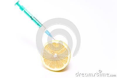 Syringe with medicine stuck in lemon. Concept of bio genetics research. Stock Photo