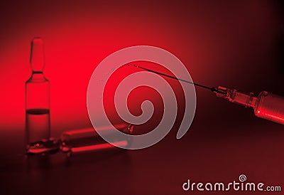 Syringe with the needle and ampule with medicine on red background Stock Photo