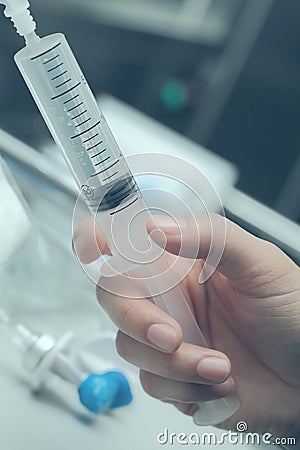 Syringe in nurse hand concept of medical treatment Stock Photo