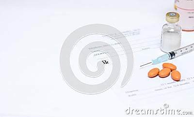 Syringe and pills on prescription pad Stock Photo