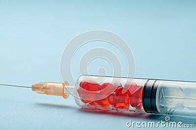 Syringe with red hearts inside. Concept for heart treatment or love potion Stock Photo