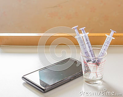 Syringe And smart phone Stock Photo