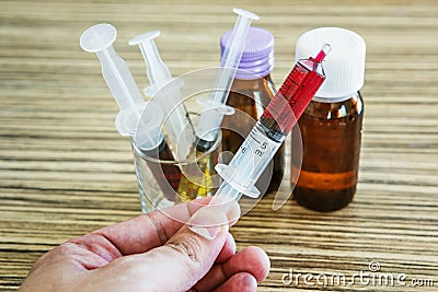 Syringe with syrup medicine on hand Stock Photo