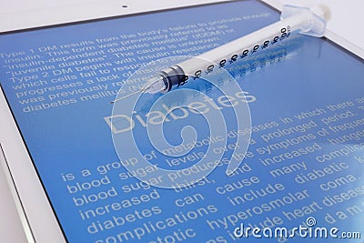 Syringe on a tablet with article about diabetes Stock Photo