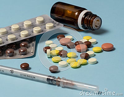 Syringe and various medications, vitamins pills laid out on a background Stock Photo