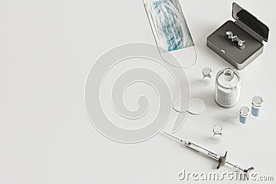 Syringe, vials, face mask on white background from above, coronavirus vaccination concept, medical supplies equipment on table, Stock Photo