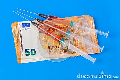 Syringes and euro money on blue background Stock Photo