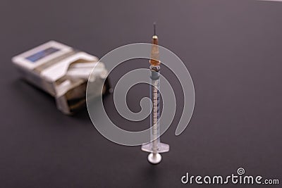 Syringes stick out of a pack of cigarettes Stock Photo