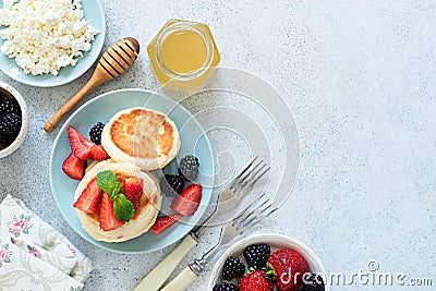 Syrniki, cottage cheese pancakes with berries and honey Stock Photo