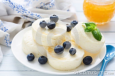 Syrniki, cottage cheese pancakes or cheesecakes with fresh berries and honey Stock Photo