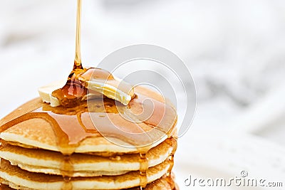 Syrup Pouring onto a Stack of Pancakes Stock Photo