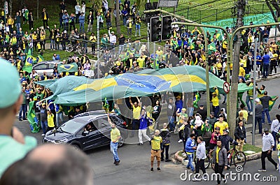 People carry the Brazilian flag across the asphalt to the crowd Editorial Stock Photo