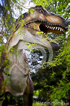 T-Rex Tyrannosaurus rex. Dinosaur model in the forest through Editorial Stock Photo