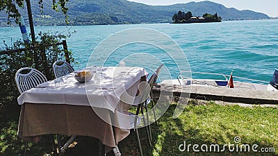 A table af restaurant on costline with boat on the lake Stock Photo