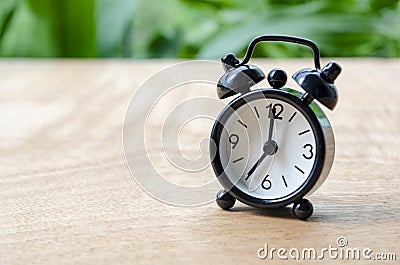 Table alarm clock pointing at 7pm or 7am with customizable space for text. Time management concept and copy space. Stock Photo