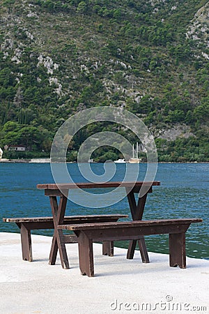 Table and benches on the pier of Kotor Bay. Montenegro Stock Photo