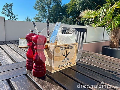 A table in a cafe or restaurant with a salt, pepper, napkins, forks, knives Stock Photo