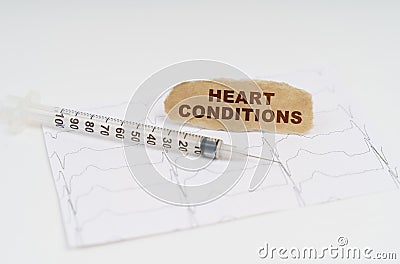 On the table is a cardiogram, a syringe and paper with the inscription - HEART CONDITIONS Stock Photo