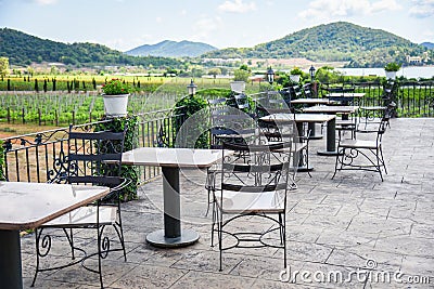 Table and chairs in the balcony of outdoor restaurant view nature farm and mountain background - dining table on the terrace Stock Photo