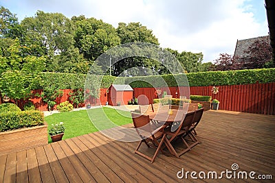 Table and chairs on decking at the back garden Stock Photo