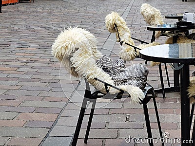 Table and chairs with fur cape outdoors near the restaurant Stock Photo