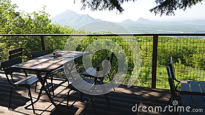 Table and chairs of one of the street restaurants with a beautiful view of the fields and mountains. Romantic meeting and outdoor Stock Photo