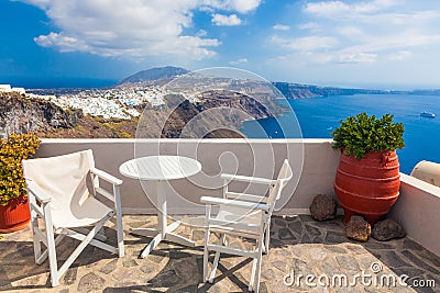 Table and chairs on roof with a panorama view on Santorini island, Greece. Stock Photo