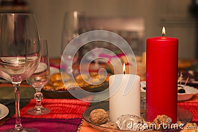 Table with christmas dinner and two lighted candles at home Stock Photo