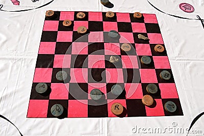 Table cloth with a checkerboard pattern and wood checkers Stock Photo