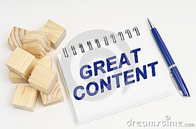 On the table are cubes, a pen and a notebook with the inscription - Great Content Stock Photo