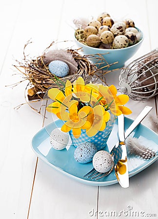 Table decoration with easter eggs nest on plate Stock Photo