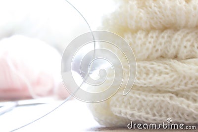 on the table lies a light sweater knitted with knitting needles and balls of threads Stock Photo