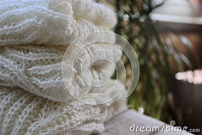 on the table lies a light sweater knitted with knitting needles and balls of threads Stock Photo