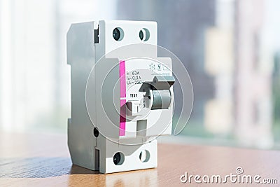 On the table lies an RCD or residual current device in modular design. Stock Photo