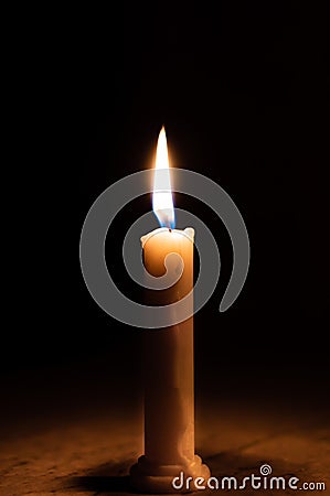 A table lit by a candle in a dark room Stock Photo