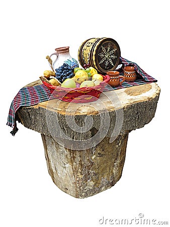 Table made of logs with fruit basket and wine barrel Stock Photo