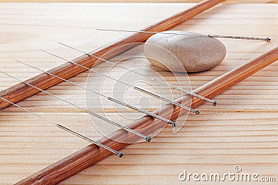 Table with needles for acupuncture. Silver needles for traditional Chinese acupuncture medicine on table. The full depth of cut Stock Photo