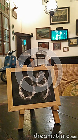 Table number 09 in a room with a vintage interior equipped with wooden chairs, Vespa motorbikes and old bicycles Stock Photo
