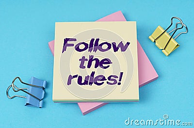 On the table are paper clips, note paper with text - Follow the rules Stock Photo