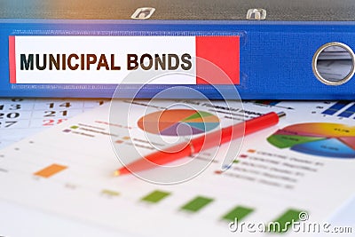 On the table are pie charts, a pen and a folder with the inscription - Municipal bond Stock Photo