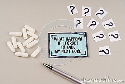 On the table are question marks and a sticker with the inscription - What happens if i forget to take my next dose Stock Photo
