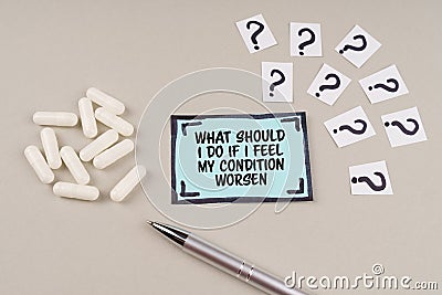 On the table are question marks and a sticker with the inscription - What should i do if i feel my condition worsen Stock Photo